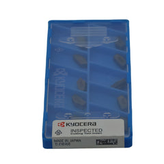 Blue Kyocera packaging with cutting tool inserts on a white background